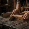 Person using a table saw to cut a piece of wood with sawdust in the air.